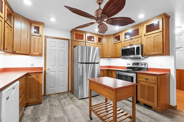 kitchen with glass insert cabinets, recessed lighting, a ceiling fan, and stainless steel appliances