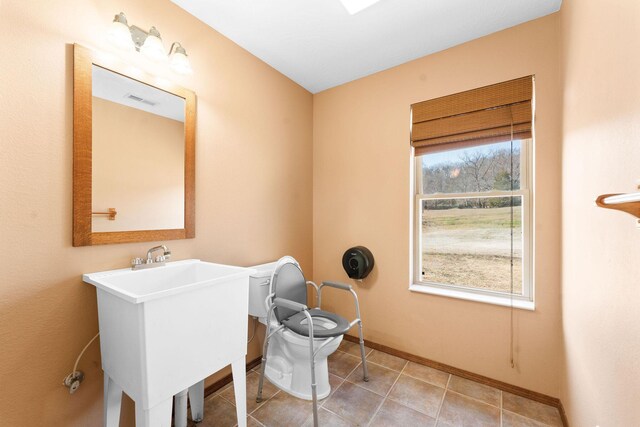 laundry room with a wealth of natural light, visible vents, baseboards, and a sink