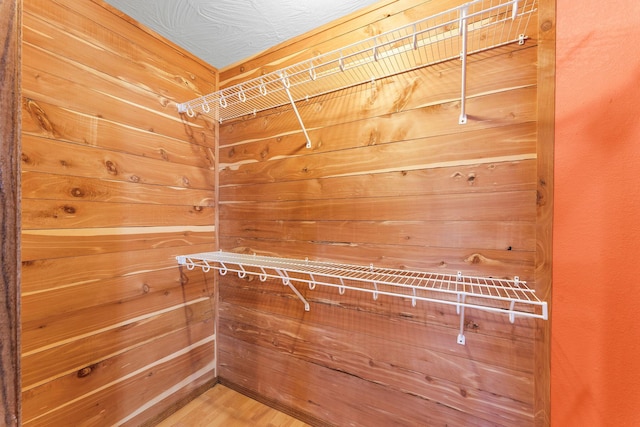 walk in closet with wood finished floors