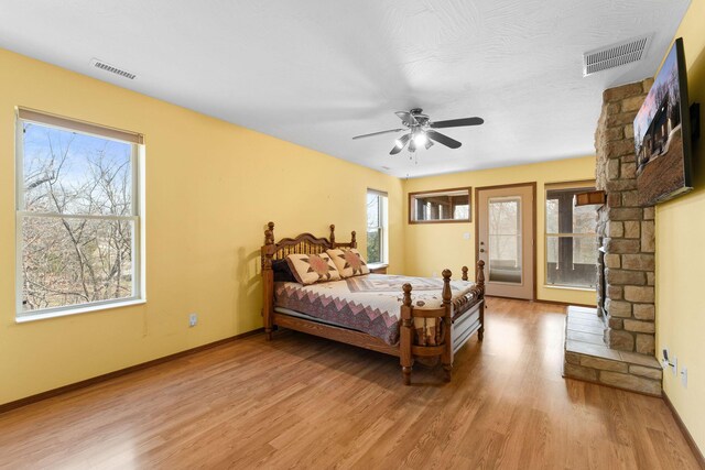 bedroom with access to outside, a ceiling fan, visible vents, and light wood finished floors