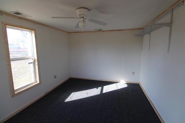 carpeted spare room featuring a wealth of natural light, visible vents, and baseboards