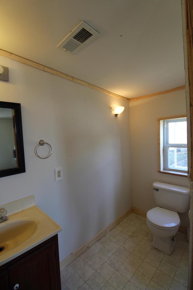 bathroom featuring visible vents, baseboards, toilet, ornamental molding, and vanity