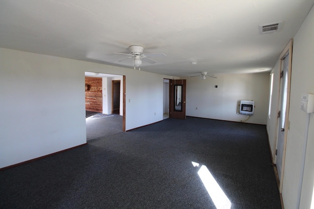 spare room featuring heating unit, visible vents, and ceiling fan