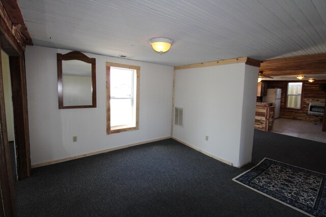 spare room featuring carpet flooring, baseboards, and visible vents