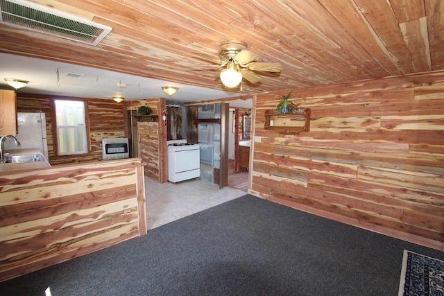 interior space featuring visible vents, wood walls, wood ceiling, heating unit, and a sink