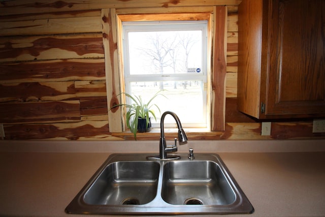 kitchen featuring light countertops, brown cabinets, and a sink