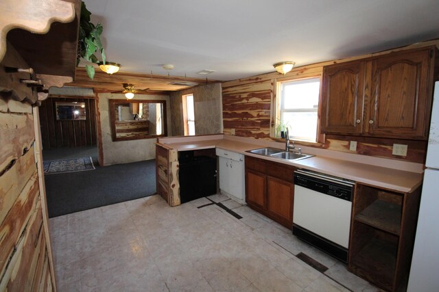 kitchen featuring white appliances, light countertops, brown cabinets, and a sink