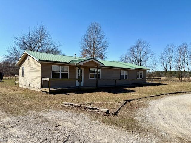 single story home featuring metal roof