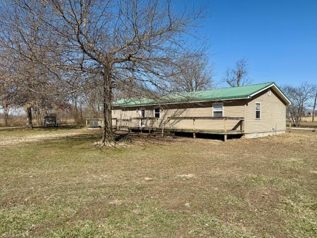 back of property with a lawn and metal roof