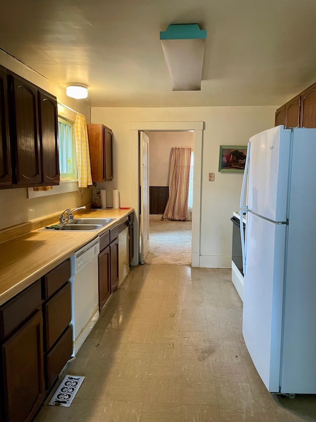 104 N High St, Neosho, MO 64850 - kitchen with dark brown cabinetry, light floors, light countertops, white appliances, and a sink