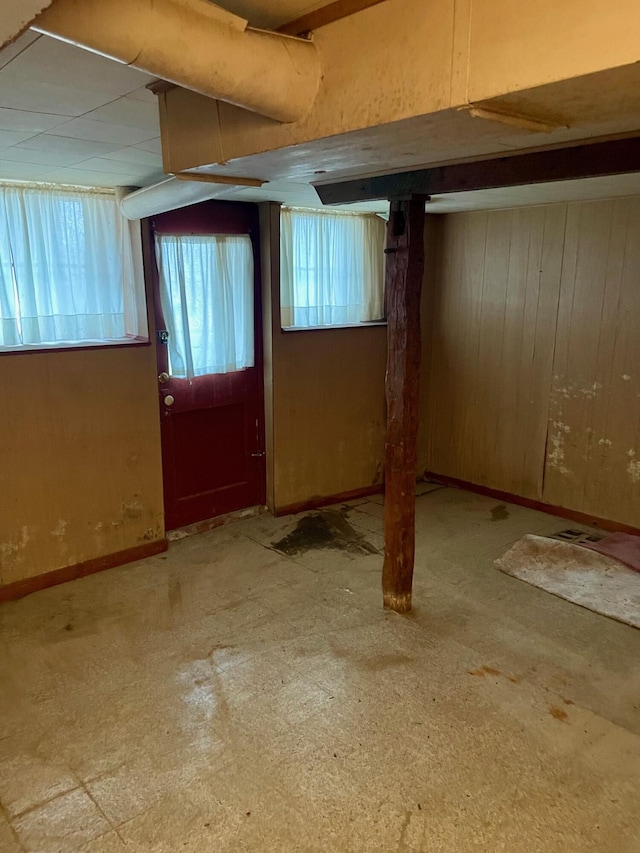 104 N High St, Neosho, MO 64850 - below grade area featuring baseboards, wooden walls, and a healthy amount of sunlight