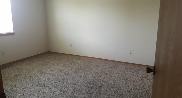 carpeted spare room with baseboards