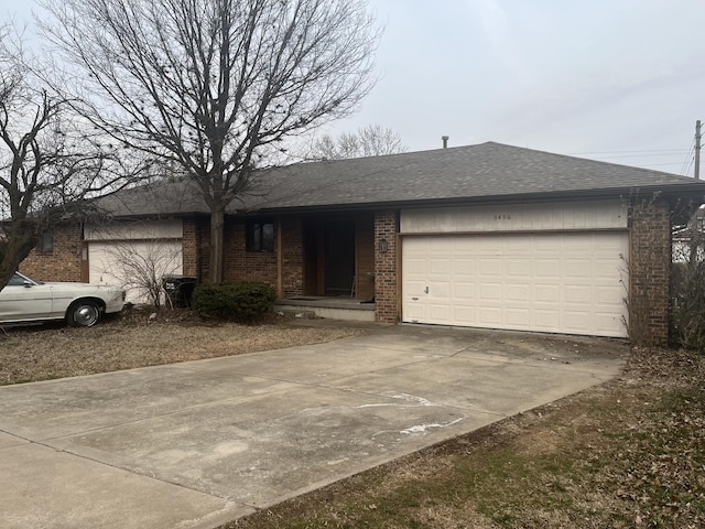 ranch-style home featuring brick siding, an attached garage, driveway, and a shingled roof