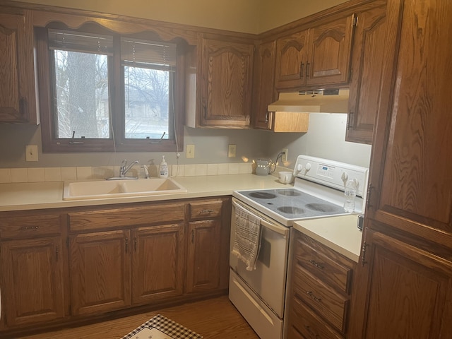3494 S Christy Ct, Springfield, MO 65807 - kitchen featuring under cabinet range hood, light countertops, brown cabinets, white range with electric stovetop, and a sink