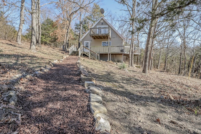 back of house with stairway, a balcony, and a deck