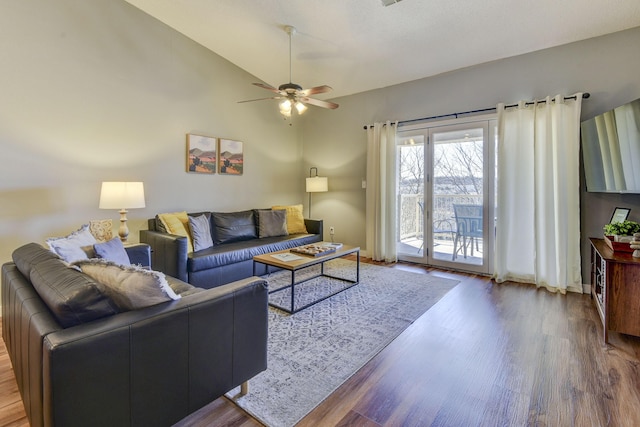 living room with vaulted ceiling, a ceiling fan, baseboards, and wood finished floors