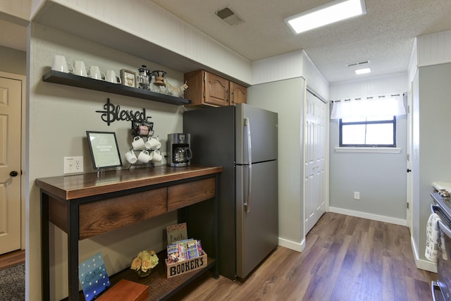 kitchen featuring dark countertops, visible vents, dark wood finished floors, and freestanding refrigerator