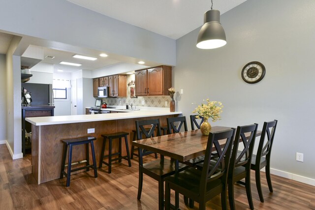 dining area with baseboards and dark wood-style flooring