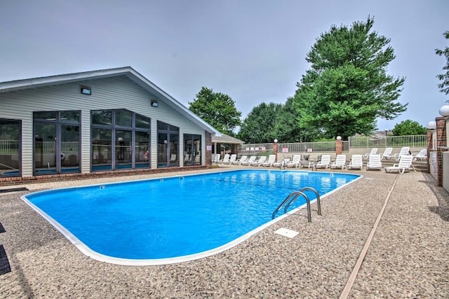 pool with a patio and fence