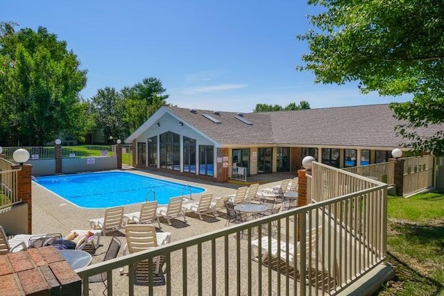 community pool featuring a patio area and fence