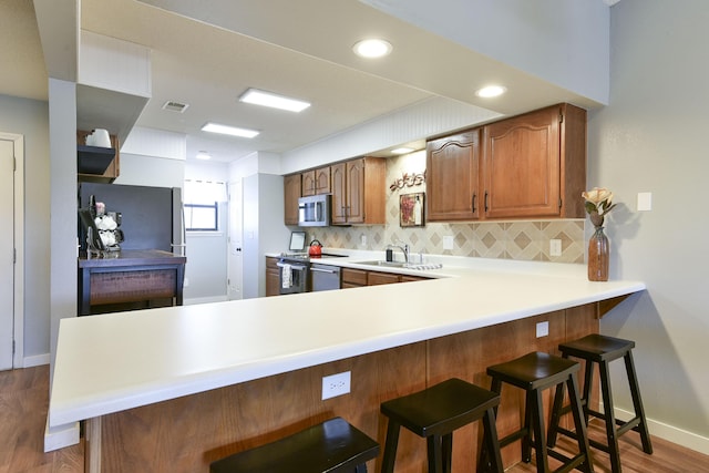 kitchen with a sink, visible vents, backsplash, and appliances with stainless steel finishes