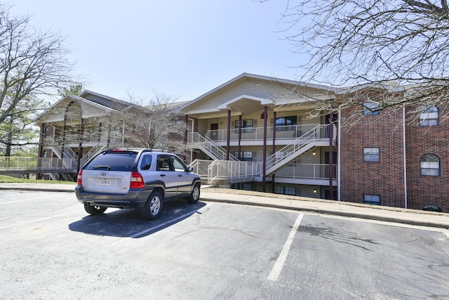 view of front of house featuring uncovered parking and stairs