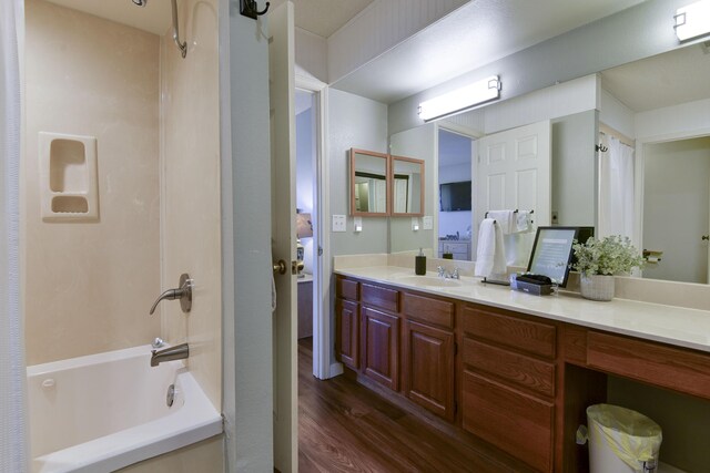 bathroom featuring shower / bathtub combination, wood finished floors, and vanity