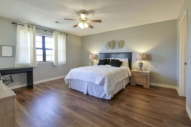 bedroom featuring visible vents, dark wood-type flooring, a ceiling fan, a textured ceiling, and baseboards