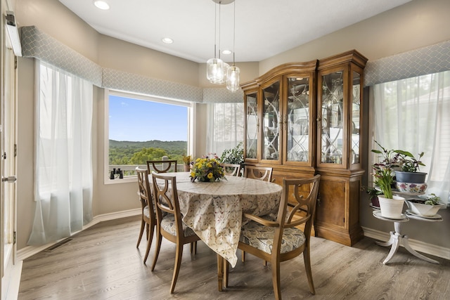 dining area featuring recessed lighting, baseboards, and light wood finished floors