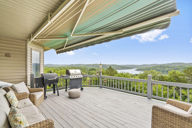 deck with grilling area and a water view