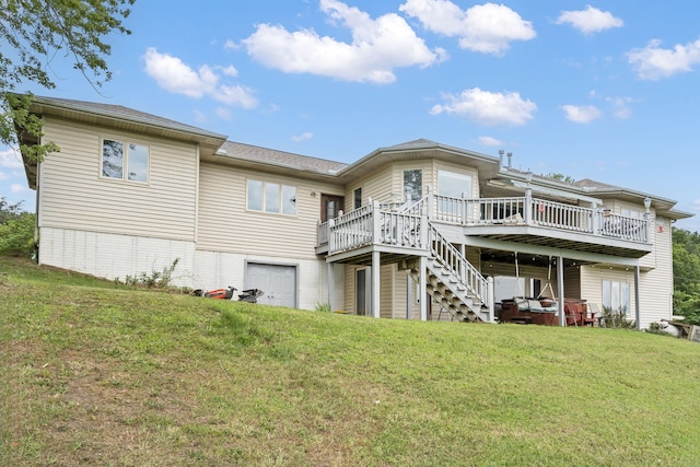 back of property with a deck, a yard, an attached garage, brick siding, and stairs