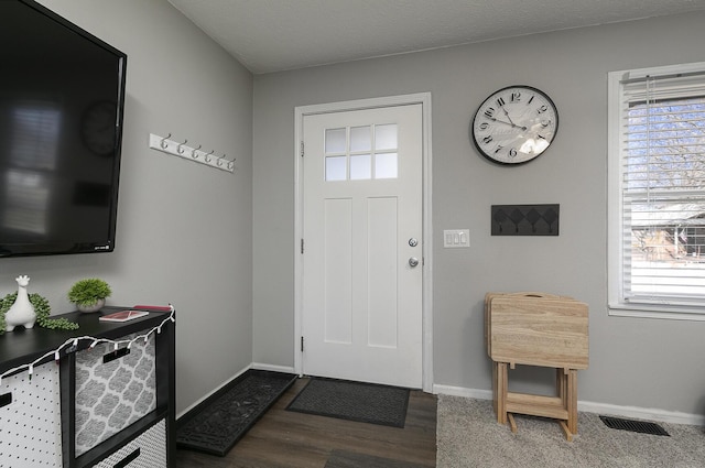 foyer with baseboards, visible vents, and a wealth of natural light