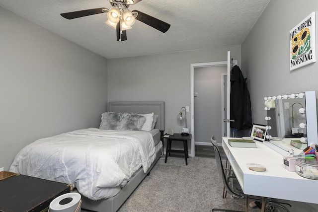 bedroom with a ceiling fan, carpet, and a textured ceiling