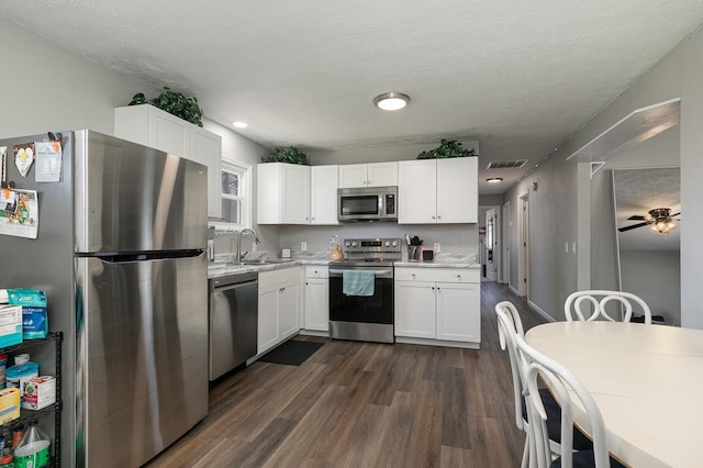 kitchen featuring visible vents, dark wood finished floors, light countertops, white cabinets, and appliances with stainless steel finishes