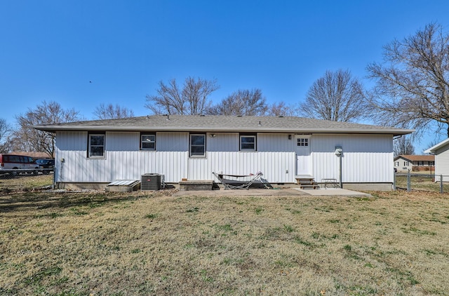 rear view of property featuring a yard, central air condition unit, entry steps, and fence