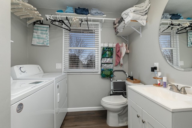 laundry area with a sink, baseboards, washing machine and dryer, laundry area, and dark wood-style flooring