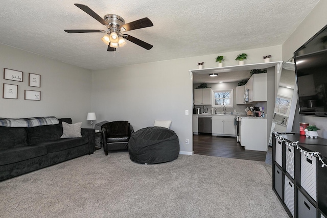 living room with a textured ceiling, ceiling fan, and dark colored carpet