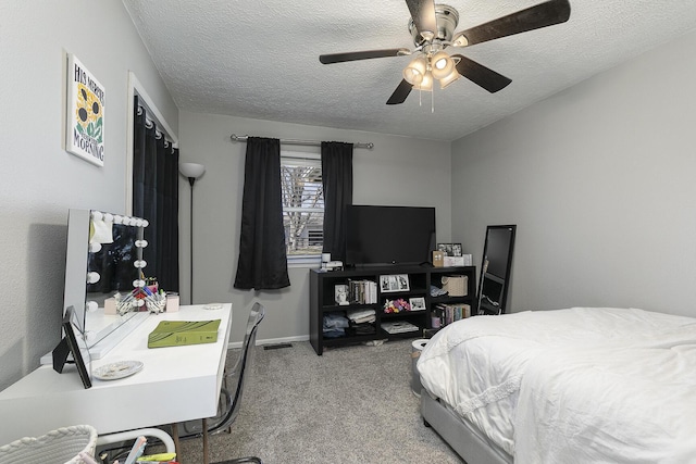 carpeted bedroom featuring ceiling fan, visible vents, baseboards, and a textured ceiling