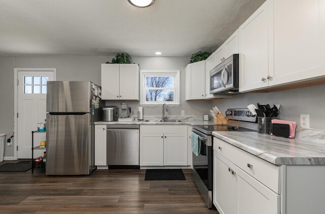 kitchen with a wealth of natural light, appliances with stainless steel finishes, light countertops, and a sink