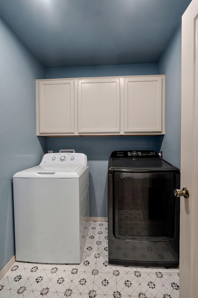 clothes washing area featuring cabinet space, independent washer and dryer, and baseboards