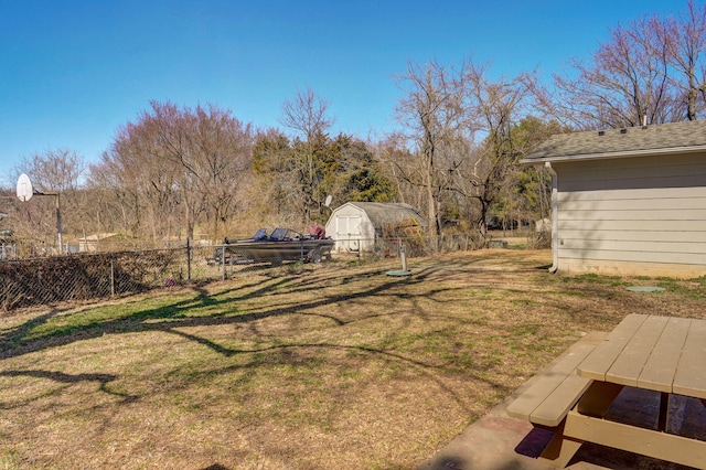 view of yard with an outbuilding, a storage unit, and fence