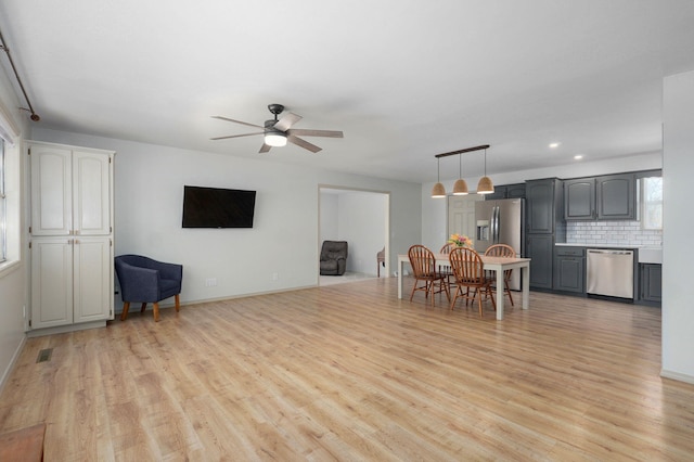 dining area featuring a ceiling fan, visible vents, light wood finished floors, and baseboards