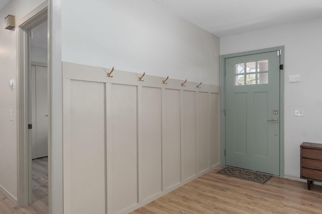 mudroom featuring a decorative wall and light wood finished floors