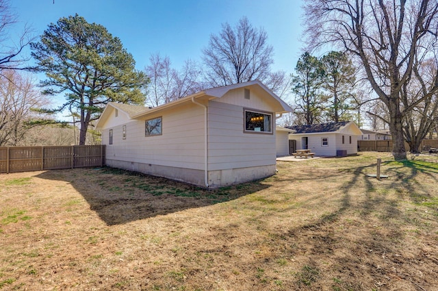 rear view of property with fence, a lawn, and crawl space