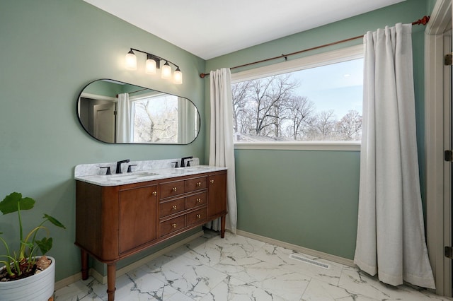 bathroom featuring visible vents, baseboards, double vanity, marble finish floor, and a sink