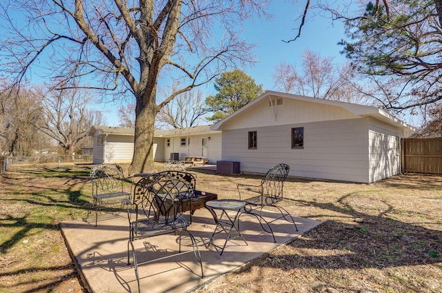 back of property with cooling unit, a patio, and fence