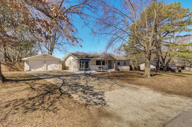 ranch-style house featuring an outbuilding, fence, and a garage