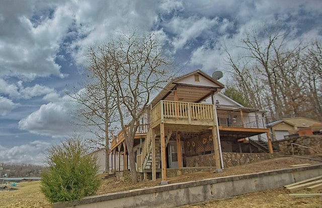 back of property featuring a wooden deck and stairs