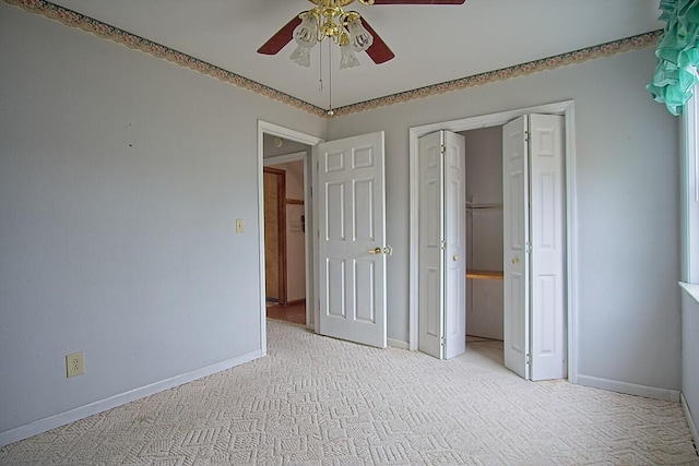 unfurnished bedroom featuring a closet, baseboards, light colored carpet, and ceiling fan