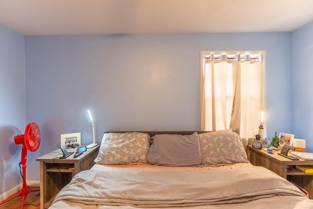 bedroom featuring baseboards and wood finished floors